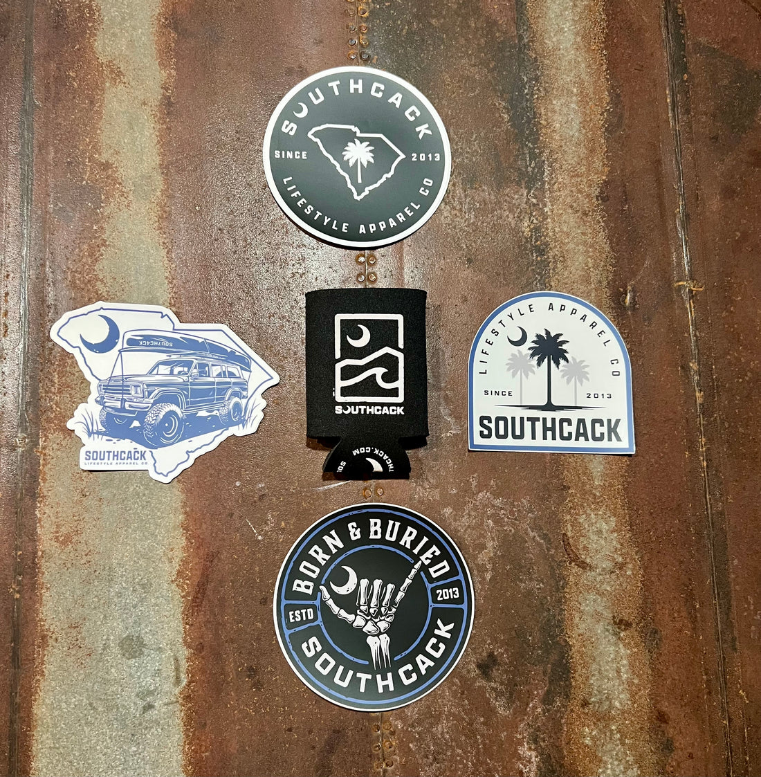 4 different designed stickers and koozie laying out